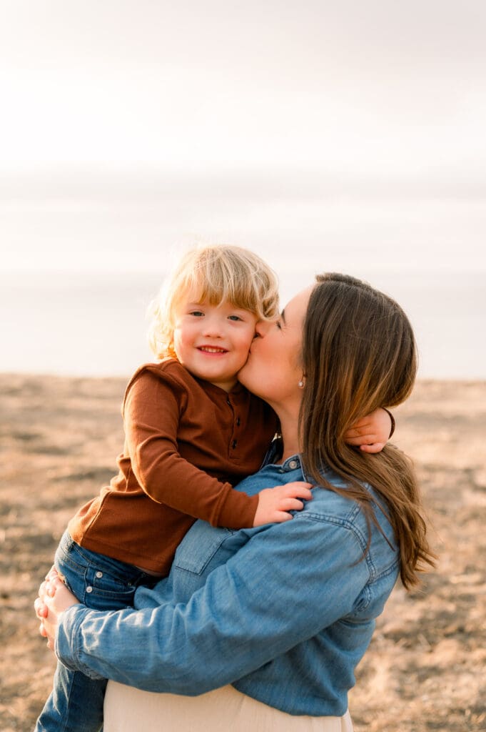Mom kissing her young son's cheek.
