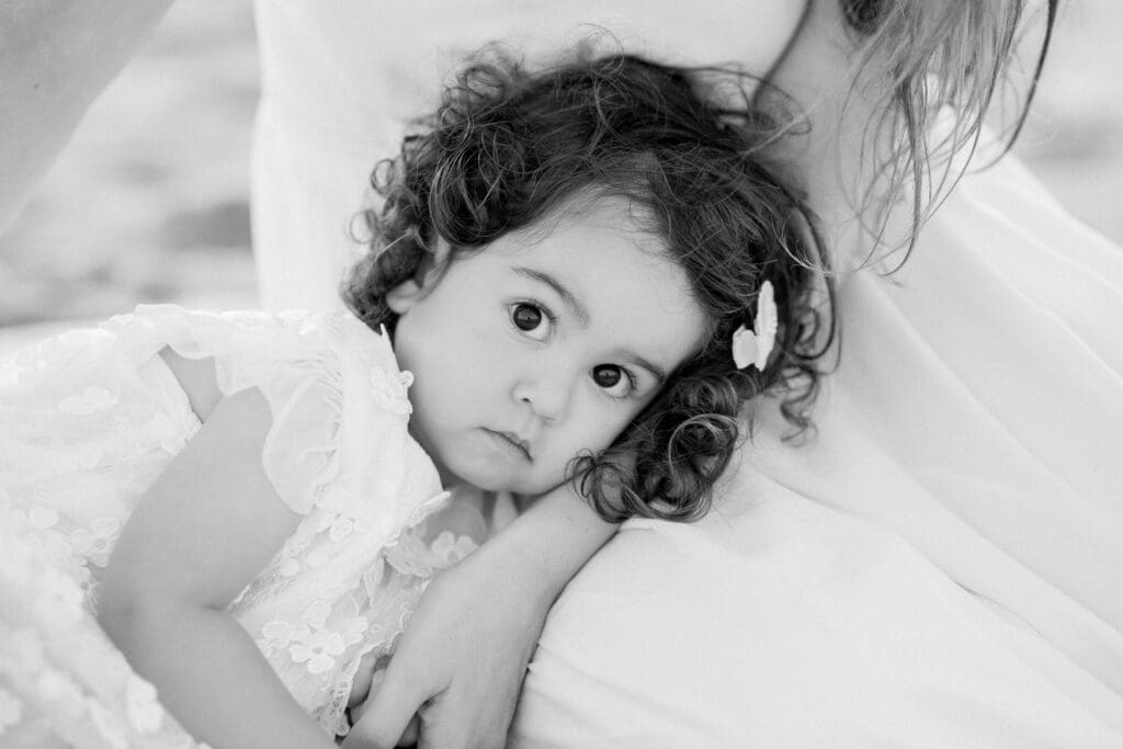 A black and white photo of a little girl with big brown eyes and curly brown hair.
