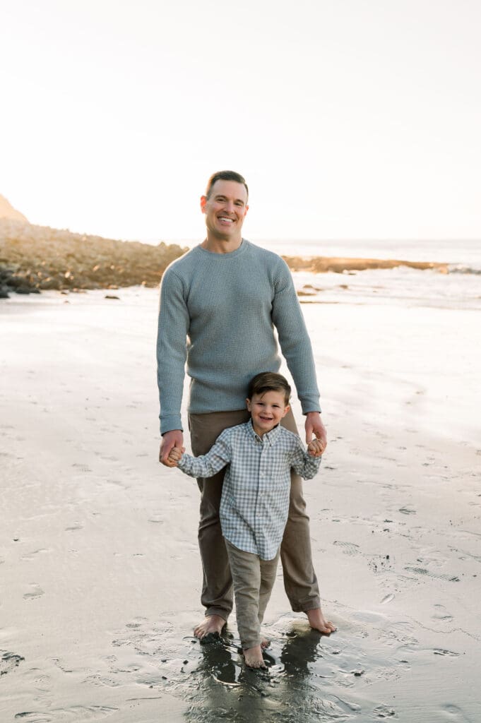A dad and his son dressed in pants and shirts, showing what to wear for family beach photos.
