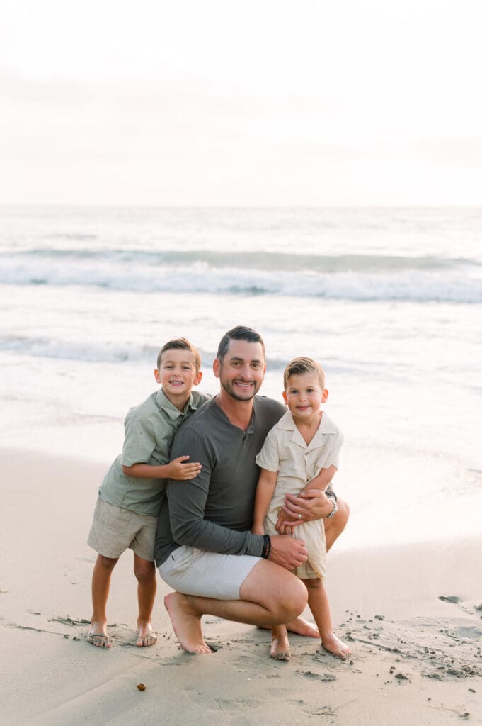 A dad and sons on the beach taking family photos in the South Bay.