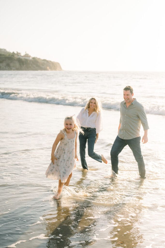 A family playing in the ocean during a beach family photography session in Los Angeles.