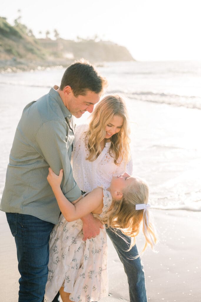 A family hugging on the beach during a family photography session in Los Angeles.
