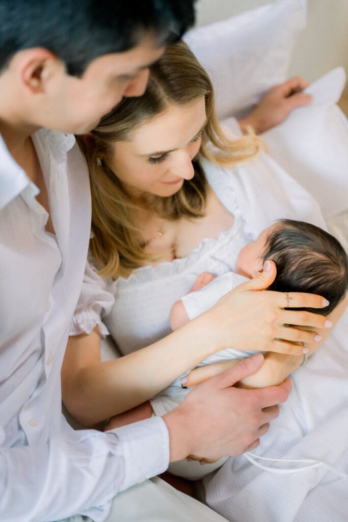 Mom and dad admiring their beautiful baby boy as they have in home newborn photos taken in Los Angeles.