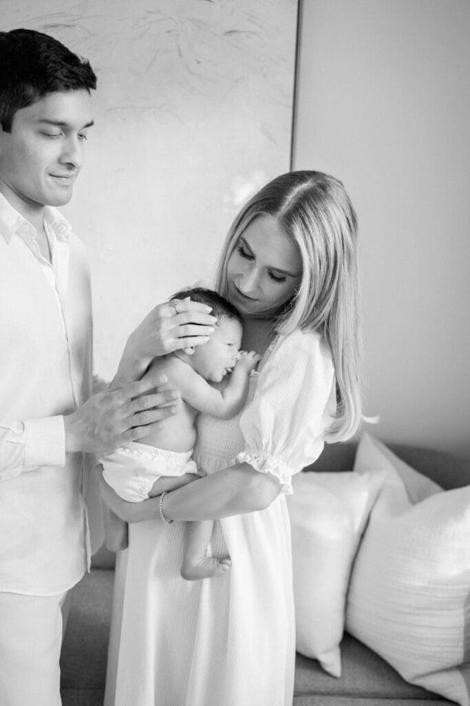An in home newborn photography session in Los Angeles featuring a mom and dad holding their baby boy.