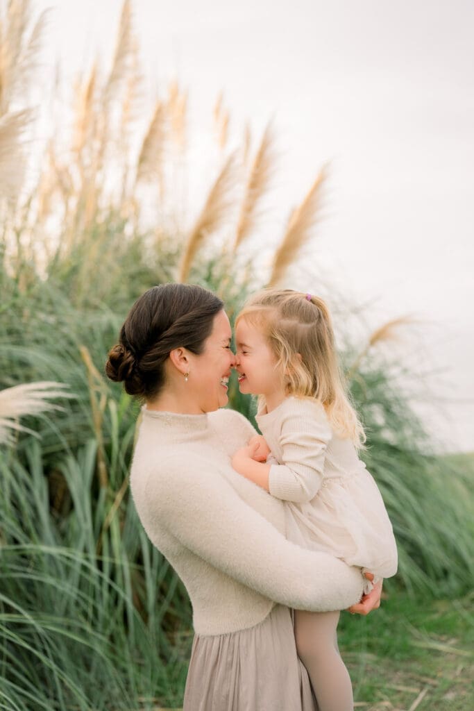 A mom and daughter smiling nose to nose during their family photo session.