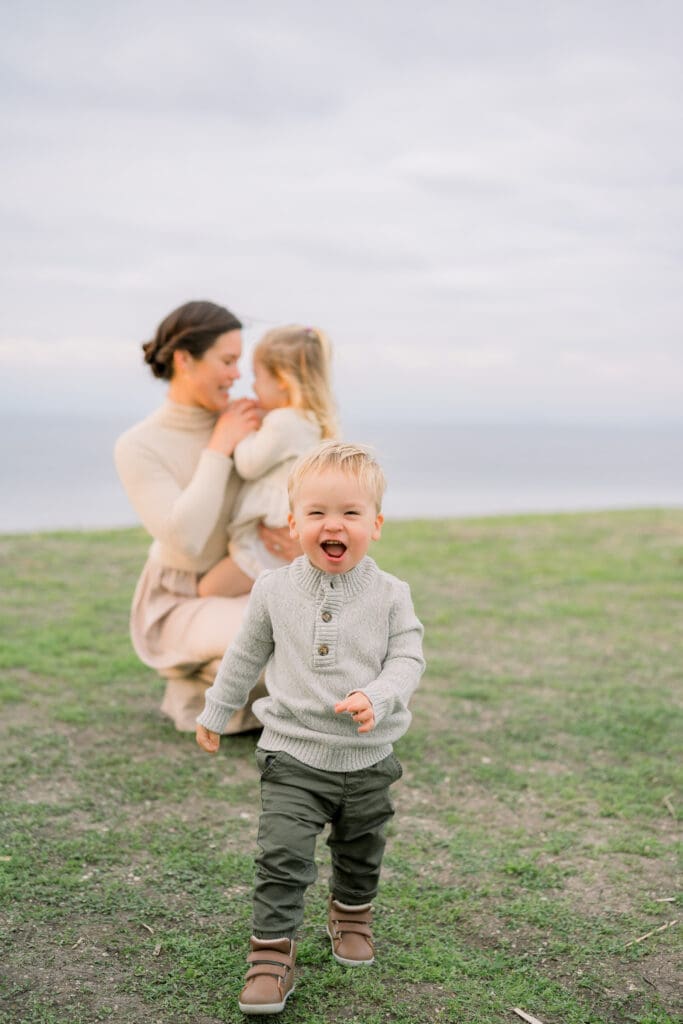 A little boy running towards the camera during a family photo session at the Palos Verdes cliffs.