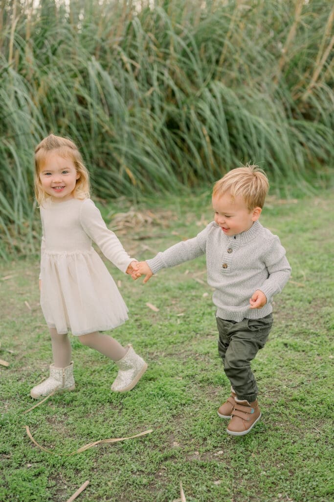 Siblings walking and holding hands.