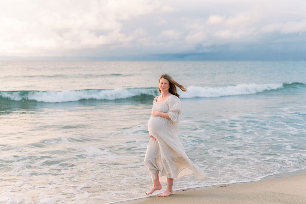 When deciding what to wear for maternity photos in Los Angeles, a barefoot look with a long flowy dress like this woman is a great idea.