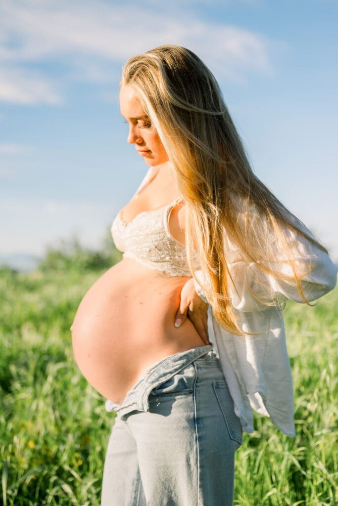 A must-have maternity pose of a mom looking down at her baby bump.