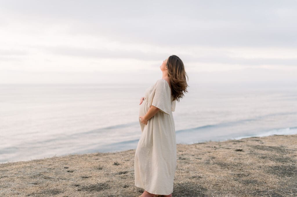 An expecting mama posing on a cliff during her Los Angeles maternity session.
