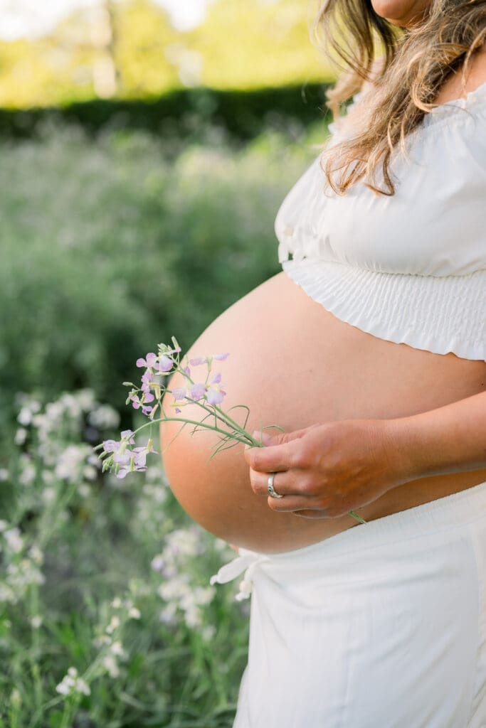 A detail shot of a pregnant mom's belly with flowers in it.
