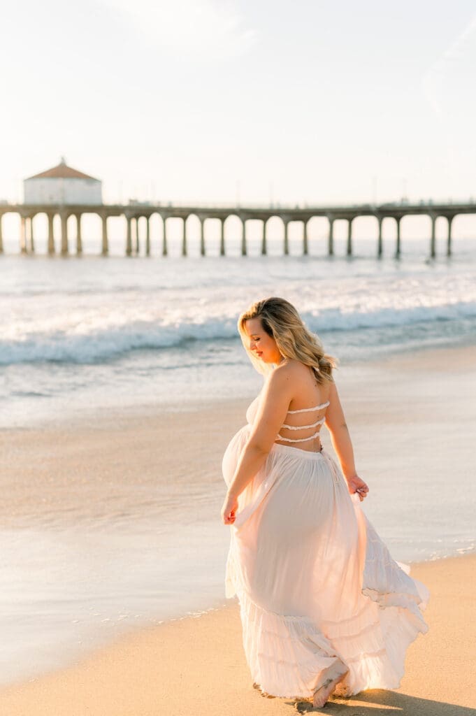 A pregnant woman on the beach at sunset during her Los Angeles maternity session.