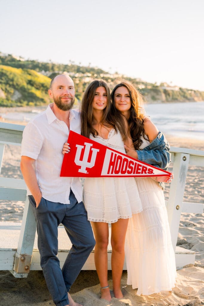 A mom, dad, and their senior daughter poses for their Los Angeles senior photo session at the beach.