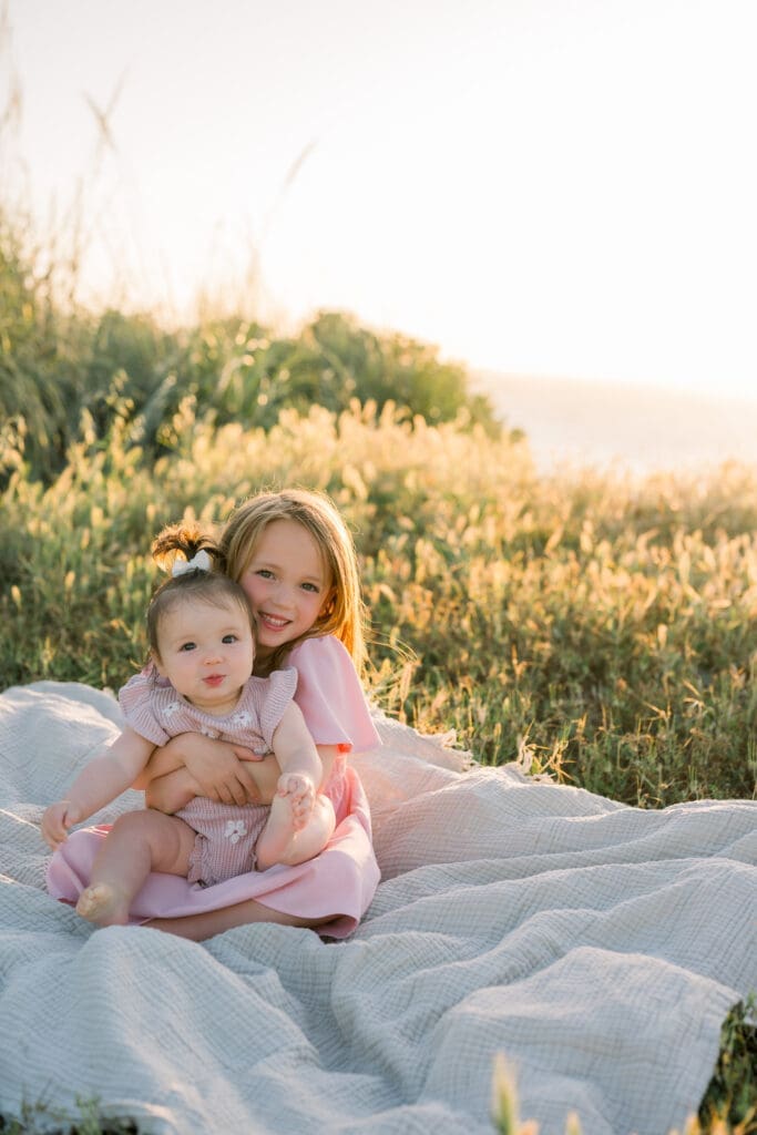 Sisters hugging while taking spring family portraits in Los Angeles.