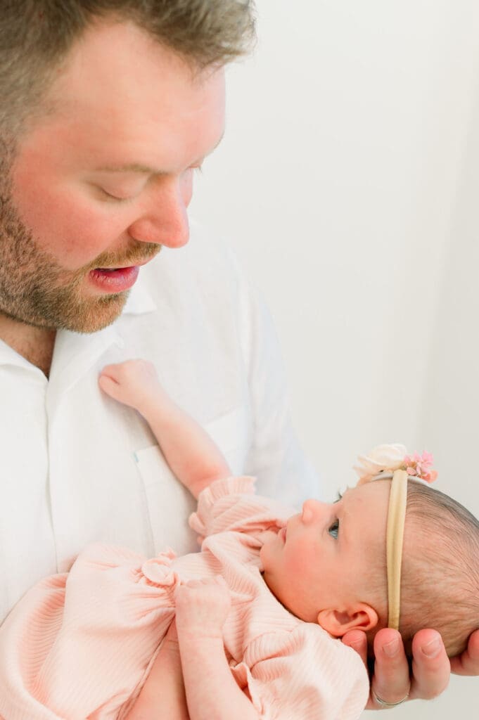 A dad looking at his baby lovingly.