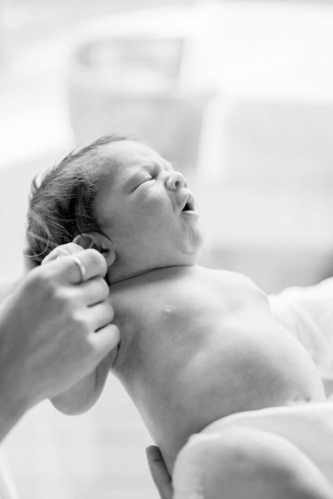 A baby in a diaper taking newborn photos.
