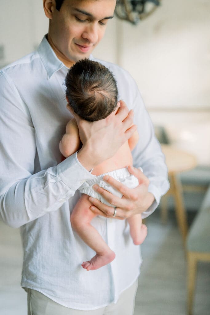 What a dad should wear for newborn photos at home with his baby.