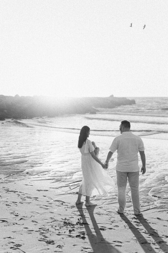 A newborn photography session featuring a family outdoors at the beach.