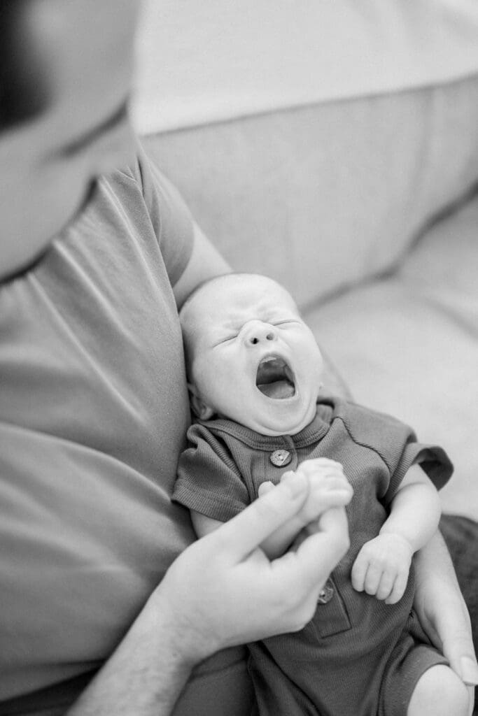 Dad holding his newborn baby during a newborn photo shoot.