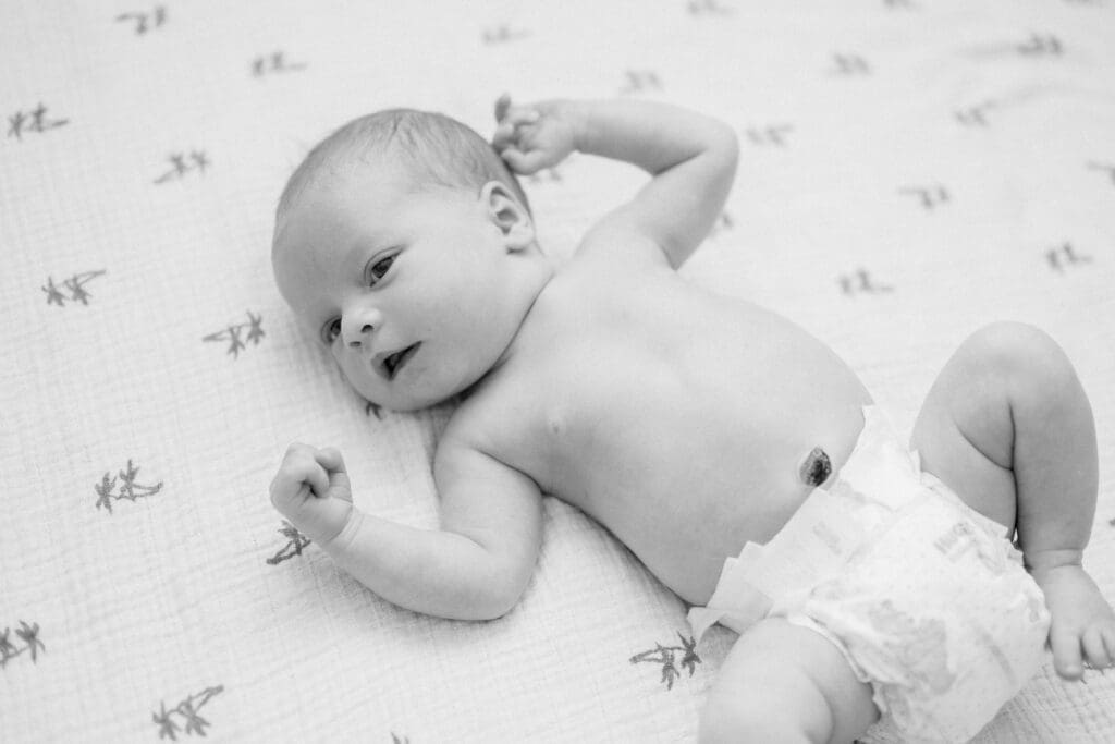 A black and white photo of a newborn baby wearing a diaper.