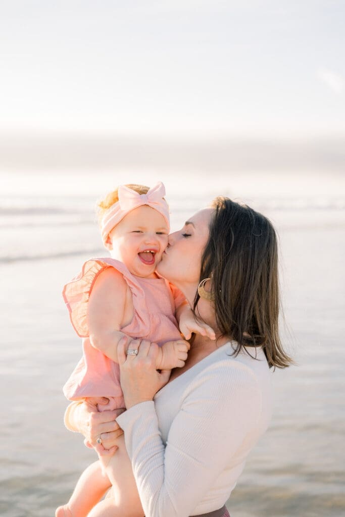 Mom kisses her baby's cheek during their family photo session taken by a South Bay photographer.