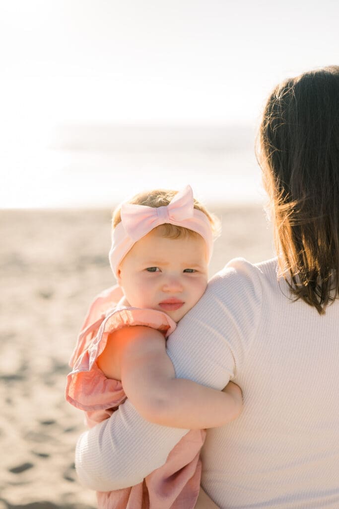 A South bay photographer takes a photo of a mom and daughter at the beach during a family mini session.