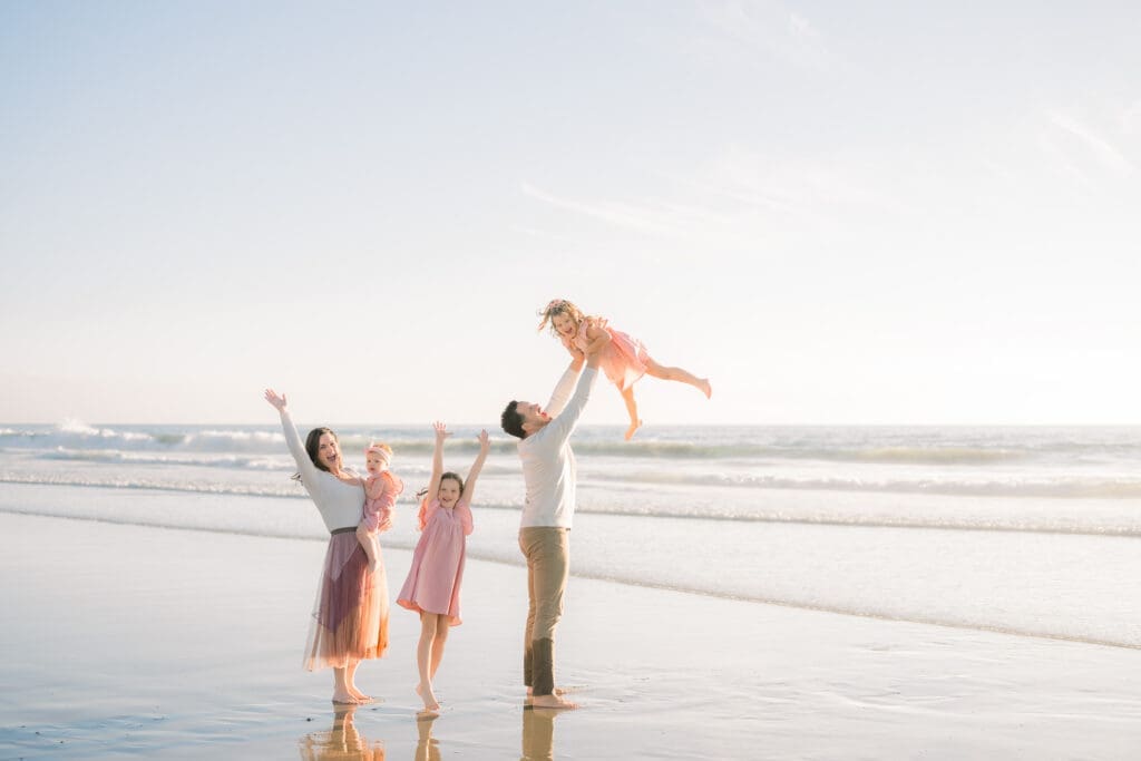 A family plays on the beach while being photographed by a South Bay photographer in Manhattan Beach.