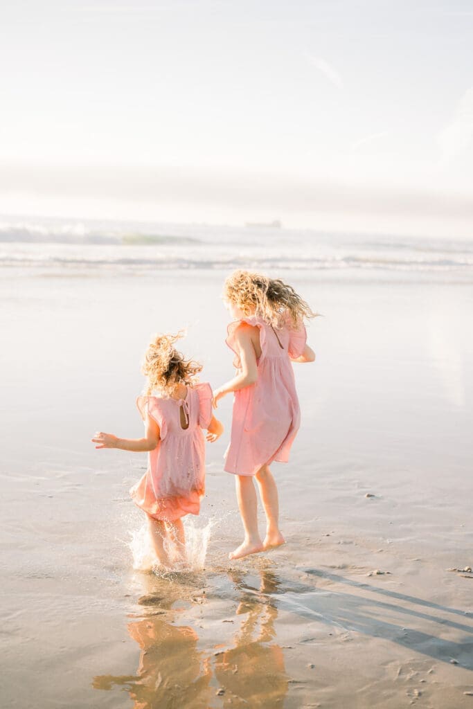 Girls jumping through the waves on a South Bay beach.