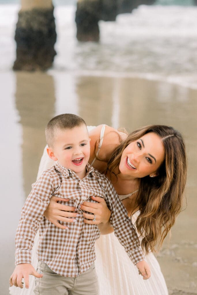 A mom and her son smiling under the Manhattan Beach pier.