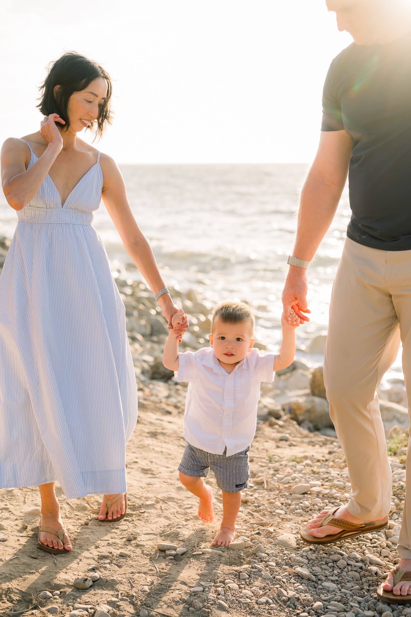 A mom and dad holding hands with their son at RAT beach, one of the best South Bay family photo locations.
