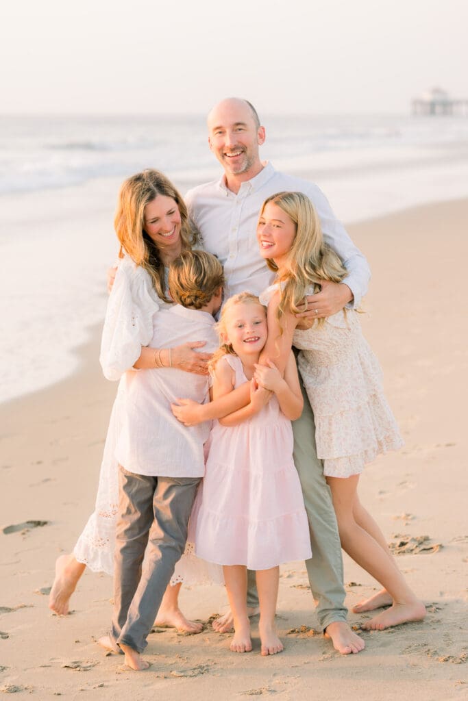 A family snuggling on the beach taking family photos in the South Bay.