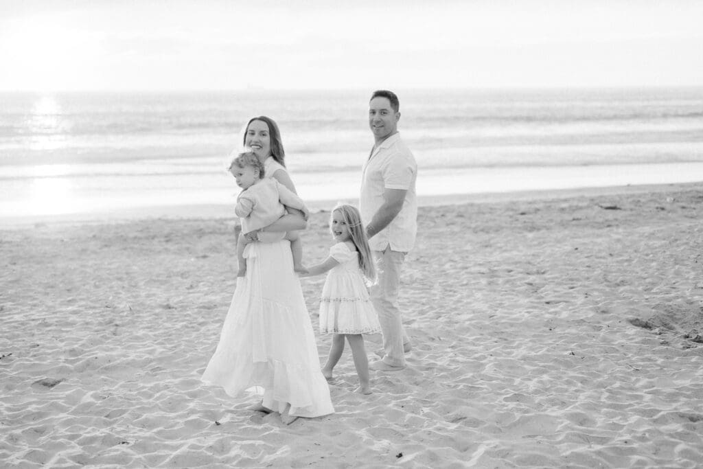 A family walking along Bruce's beach in Manhattan Beach taking family photos.