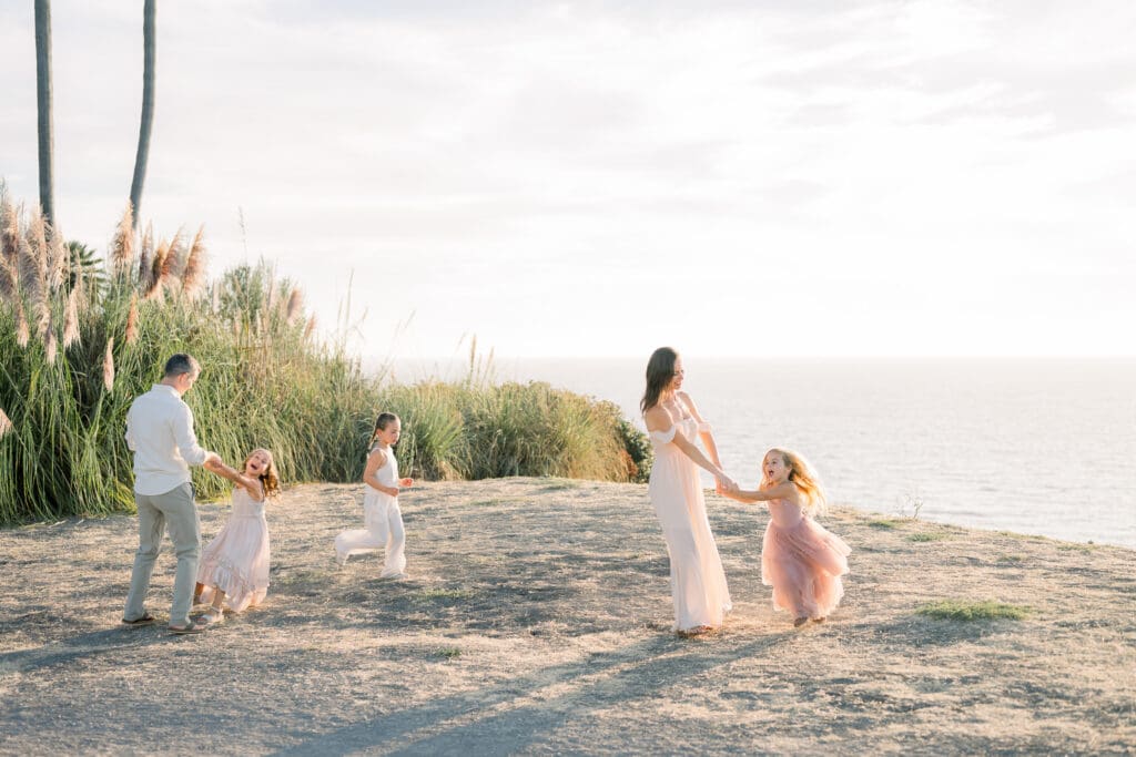 A family playing along the Palos Verdes cliffs, one of the best South Bay family photo locations.