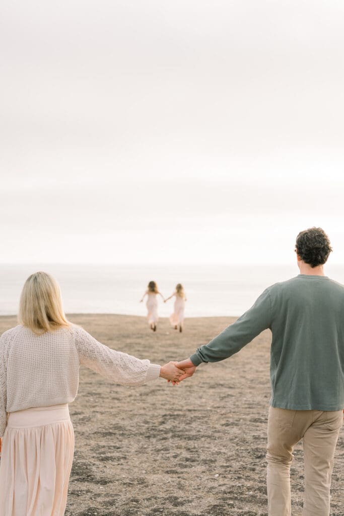 A family holding hands in Lunada Bay at a cliffside family photo location.
