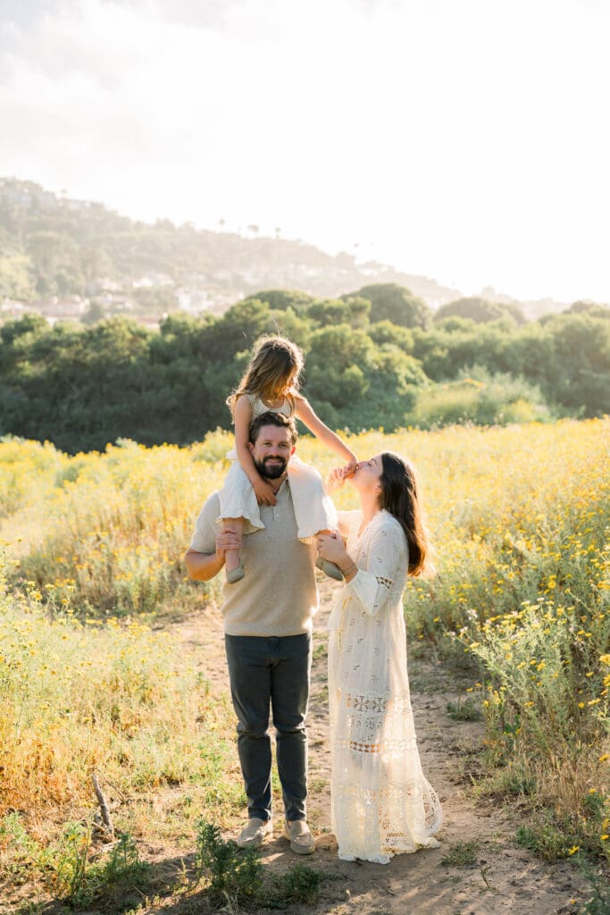 A family taking family photos in the wildflowers of Palos Verdes.