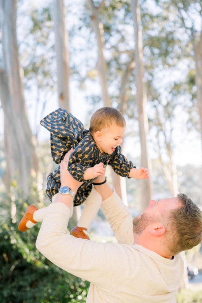 Dad lifting up his little girl while they take family photos in Palos Verdes.