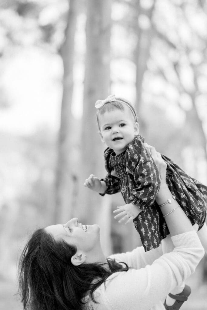 A mom holding her little girl and smiling.