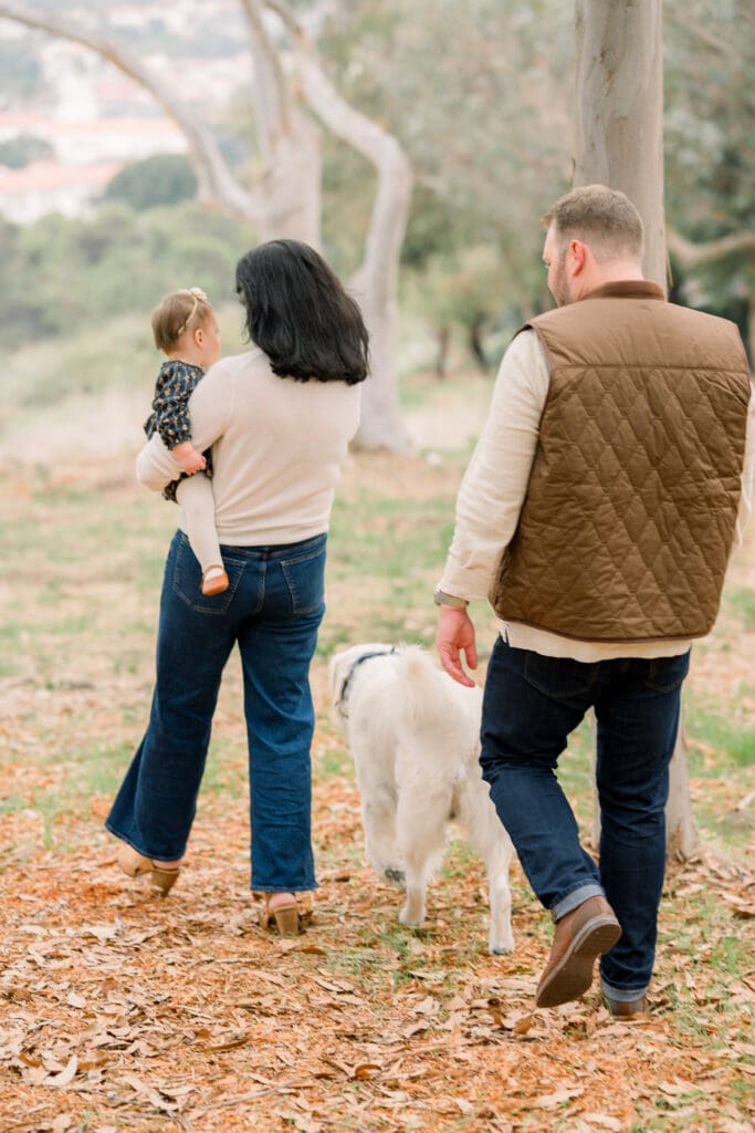 One of the best fall family photo locations featuring a family walking with their dog.