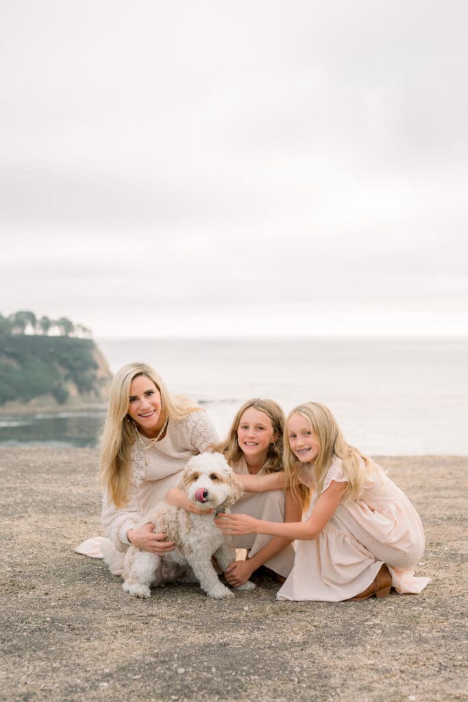 A family snuggling with their dog during their family photo session in Palos Verdes.