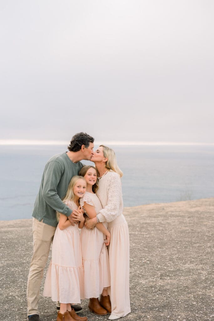A family snuggled up together taking family photos in the South Bay.